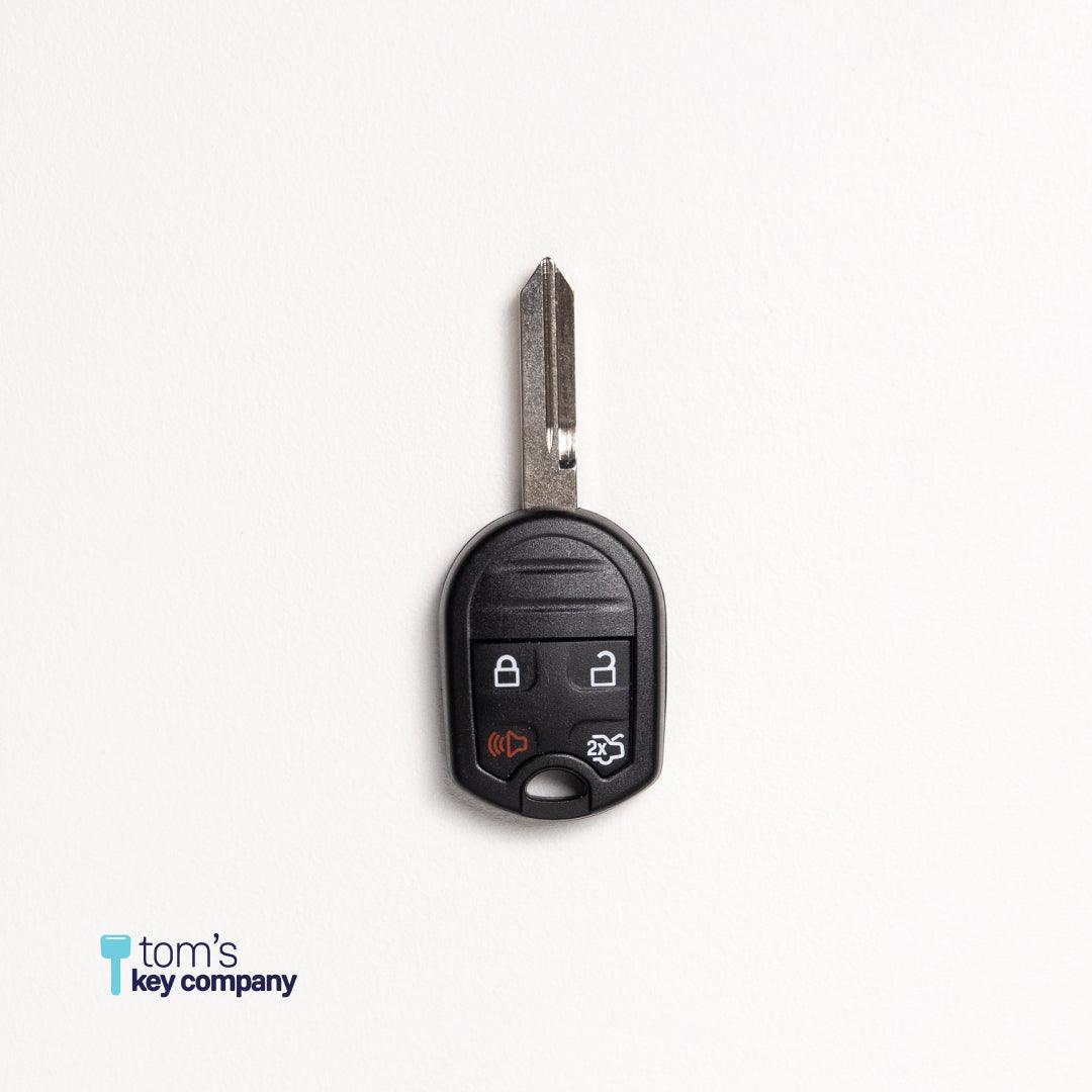 Car key fob with key blade on a white background, branded 'Tom's Key Company'.